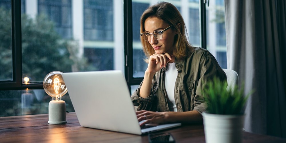 Woman looking at a laptop screen, wondering if tax app hosting is right for her.