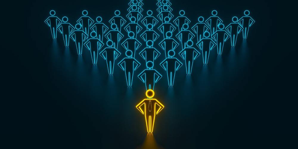 An image of a robotic-looking leader outlined in neon yellow in front of a group of other robotic-looking employees.