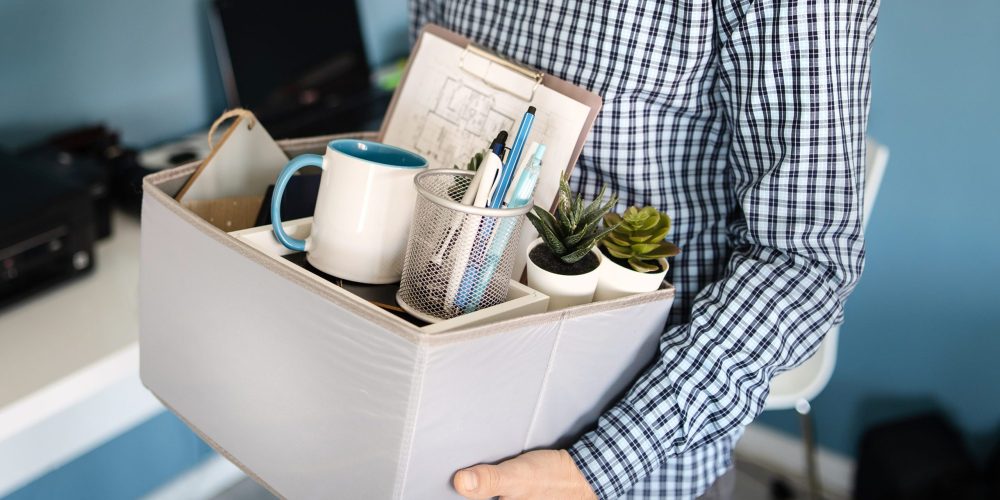 Person with a box of their work items.