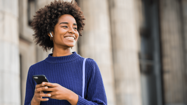 A woman listens to an accounting-focused podcast while walking through the city on her way to work.