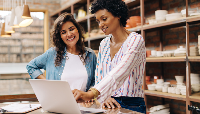 two woman looking at laptop