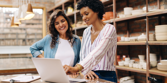 Two women looking at laptop as they go through their small business cybersecurity guide