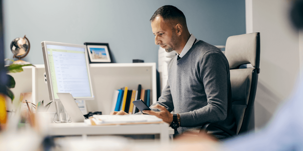 Man looking at a desktop, wondering about value-based pricing and the future of his accounting firm.